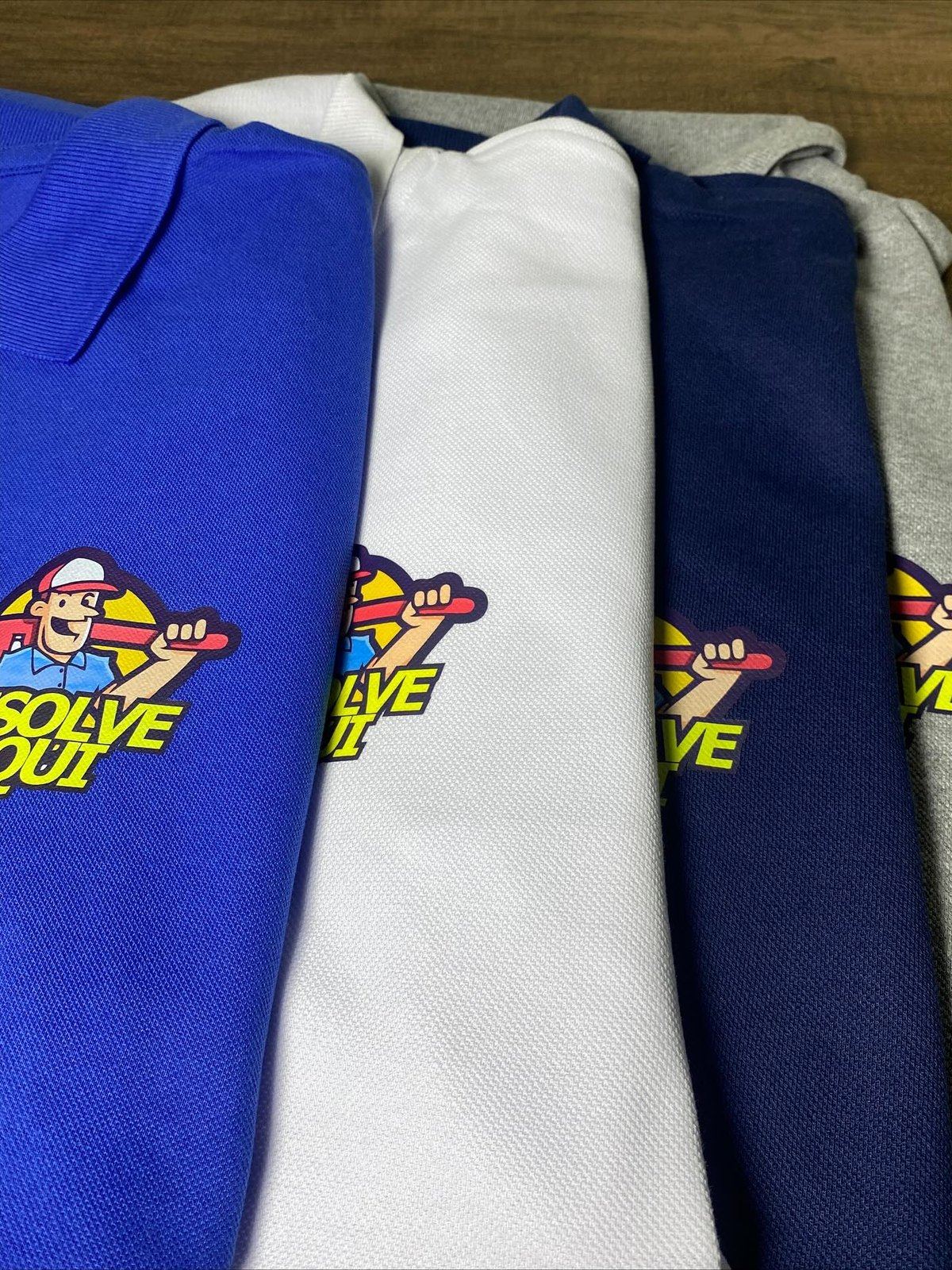 Quatro camisas polo em azul royal, branco, marinho e cinza mescla com a mesma aplicação